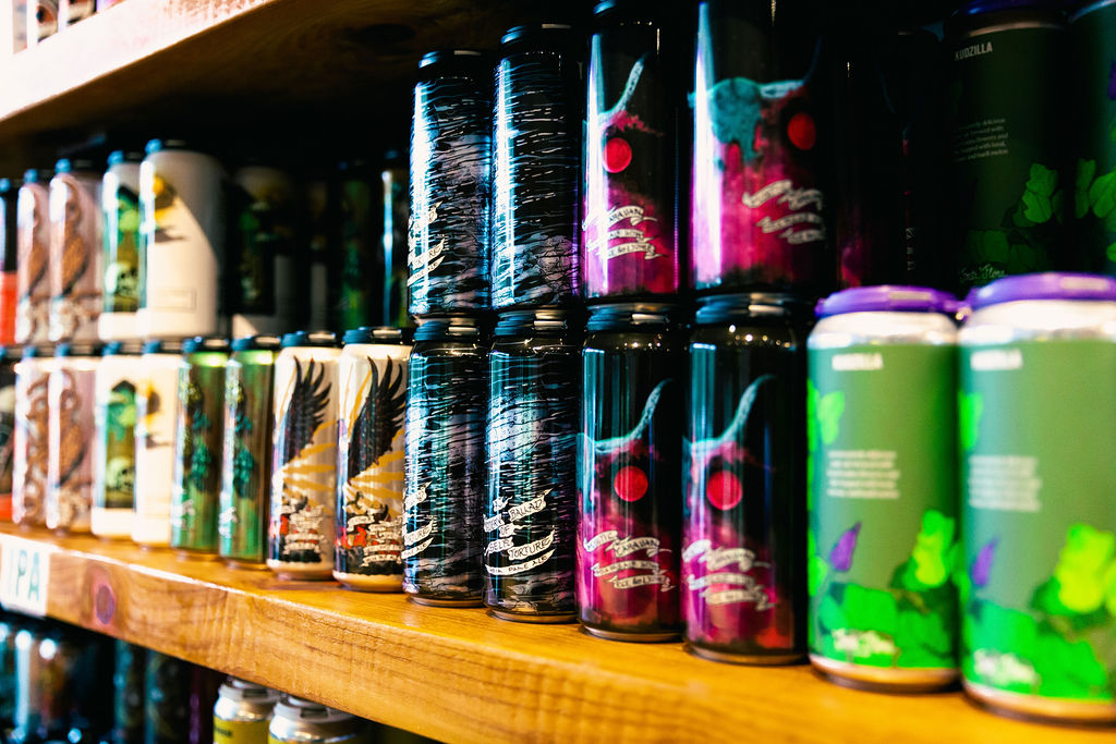 a shelf of cans at a bottle shop