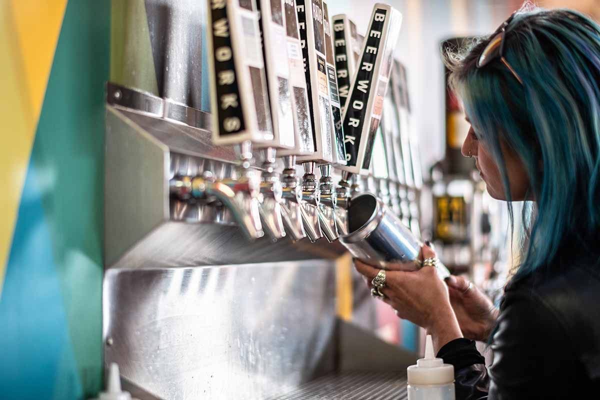 Beer tender filling a crowler with beer