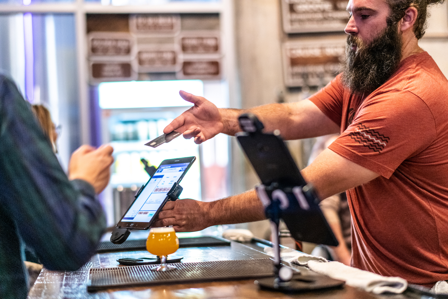 Beertender hands credit card back to guest at the bar