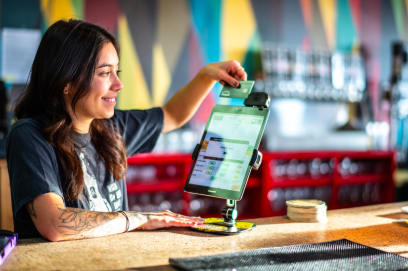 Server swipes credit card at the bar