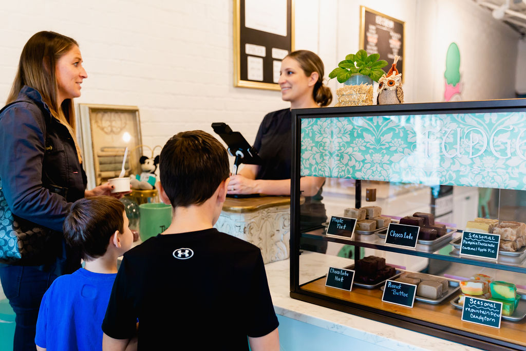 Mom and two sons ordering at a counter while worker uses a must have POS system.