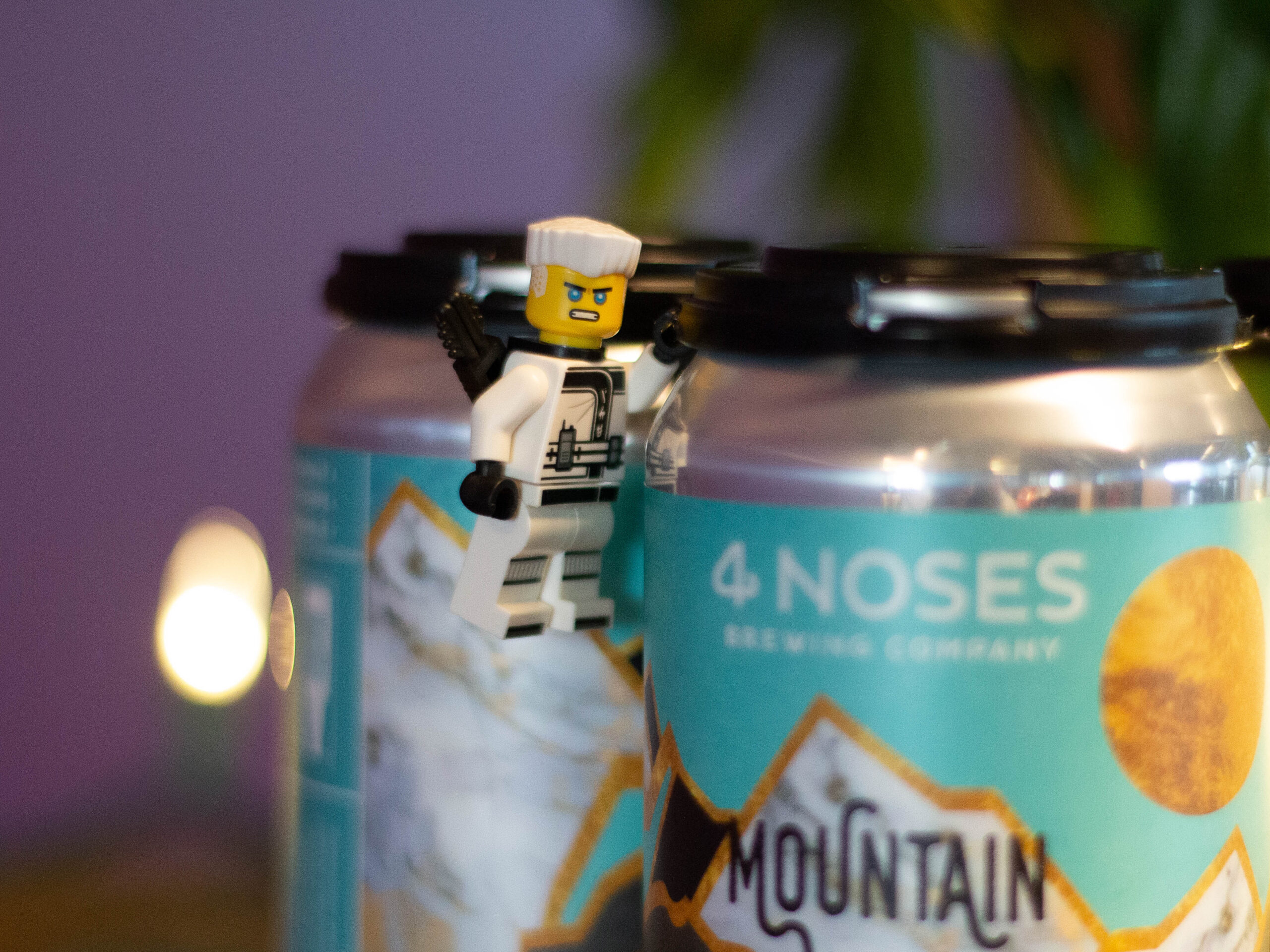 Lego figure climbing on beer caps from 4 Noses Brewing Company
