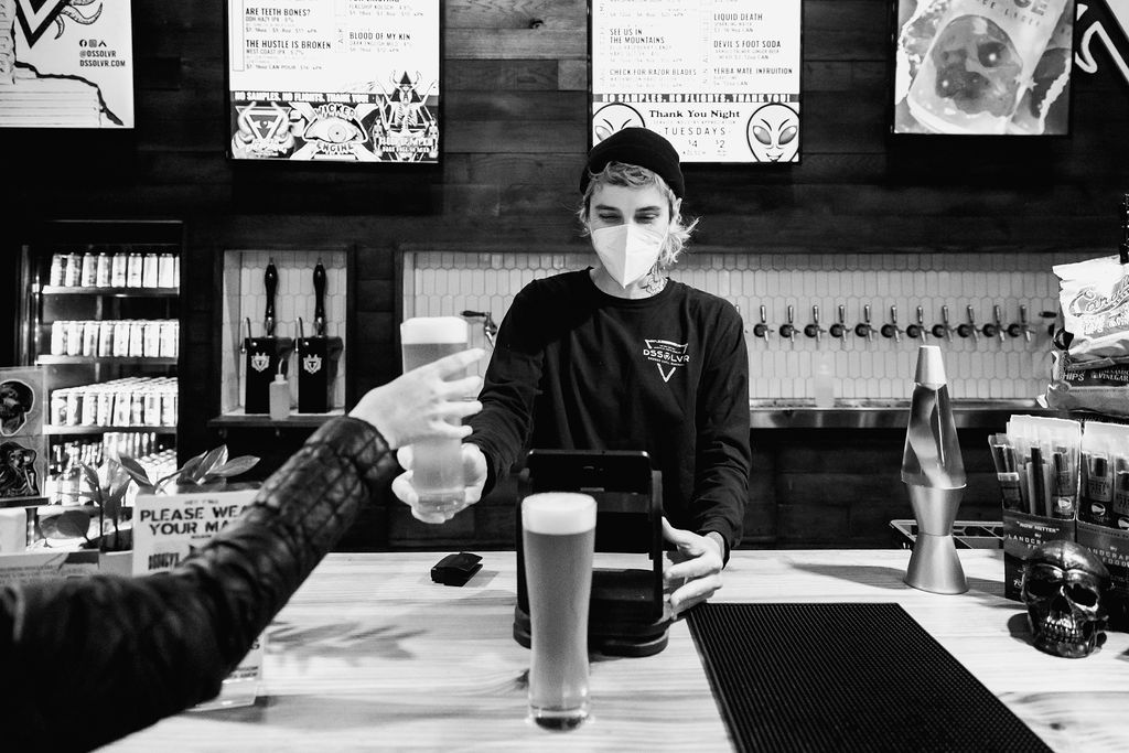 DSSOLVR bartender serving a cold glass of beer and ringing in a beer.