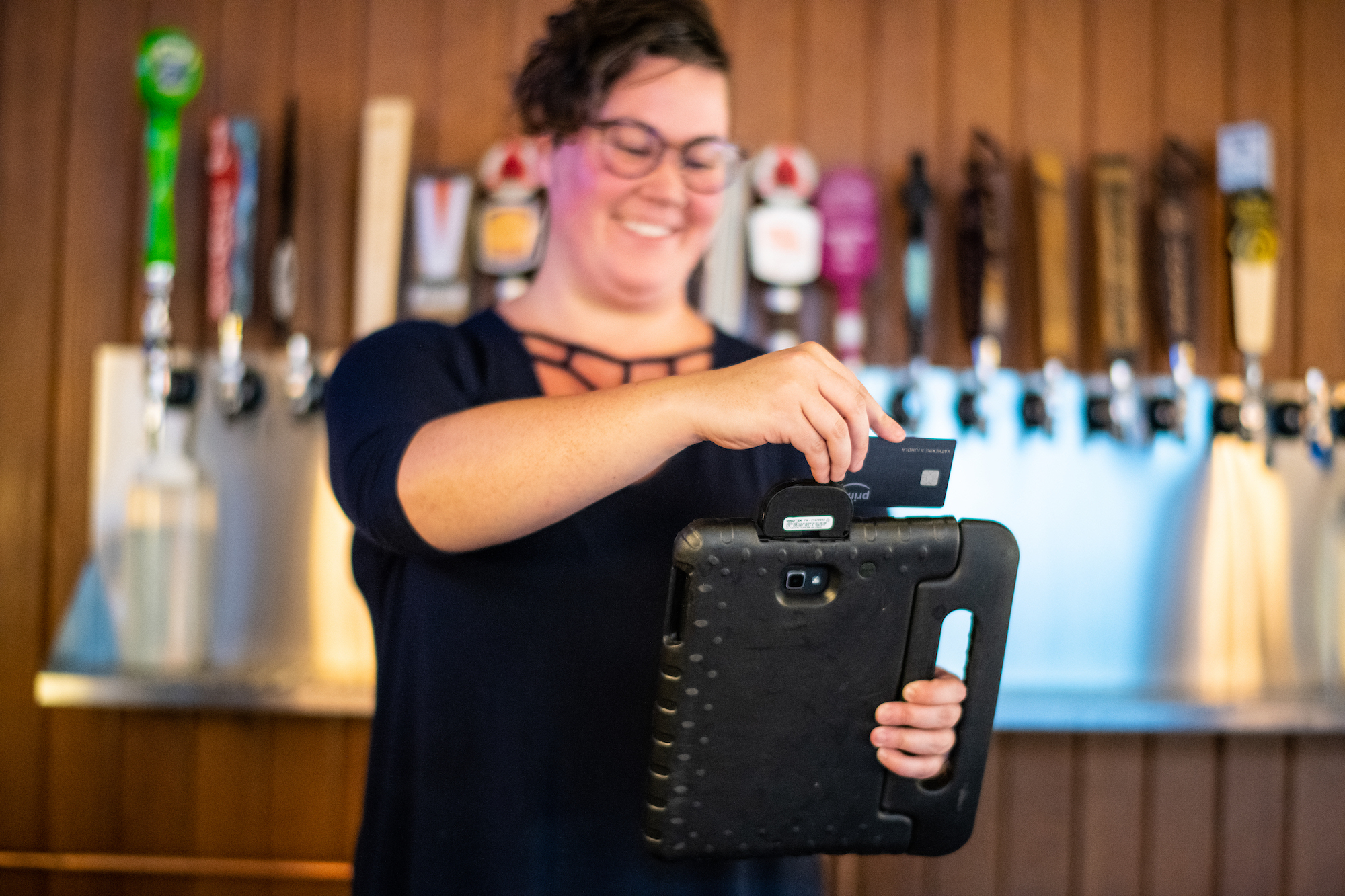 Lady swiping card on tablet with card reader